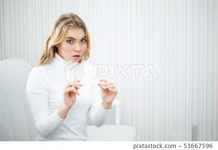 Positive pregnancy test. Portrait of desperate young woman holding pregnancy test stick 53667596