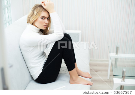 Positive pregnancy test. Portrait of desperate young woman holding pregnancy test stick 53667597