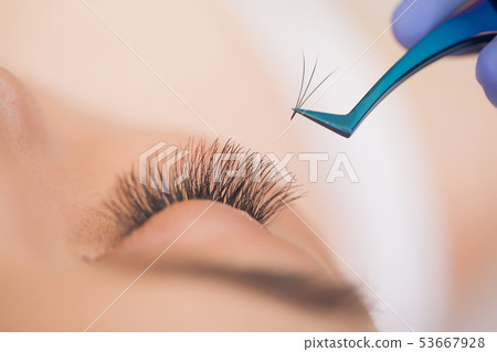 Eyelashes extensions. Fake Eyelashes. Eyelash Extension Procedure. Professional stylist lengthening Eyelashes extensions. Fake Eyelashes. Eyelash Extension Procedure. Professional stylist lengthening 53667928