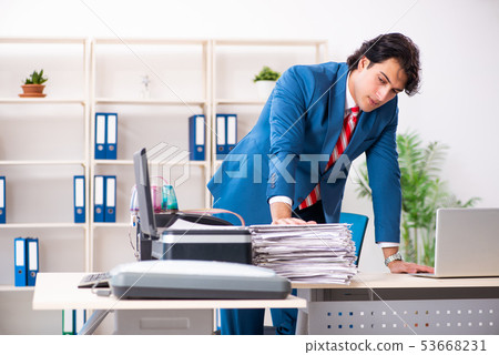 Young employee making copies at copying machine Young employee making copies at copying machine 53668231