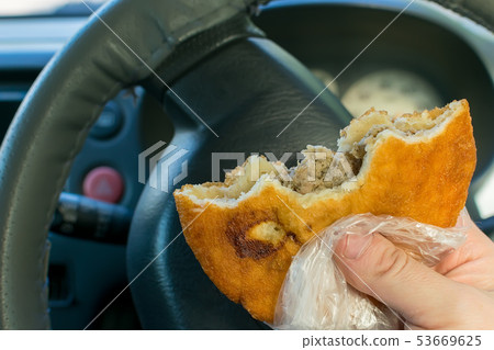 pie, belyash in the hand of the driver in the car pie, belyash in the hand of the driver in the car 53669625