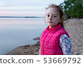 Beautiful pensive teen girl with freckles by sea at sunset 53669792
