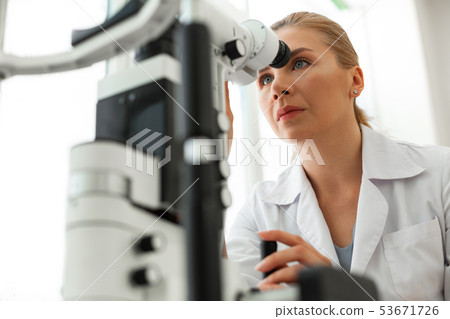 Attentive blonde oculist working with innovative technique Attentive blonde oculist working with innovative technique 53671726