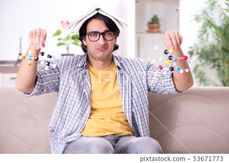 Young student physicist preparing for exam at home Young student physicist preparing for exam at home 53671773