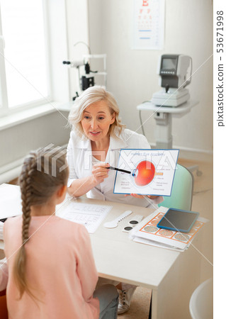 Pleasant good-looking lady pointing on elements of eye structure 53671998