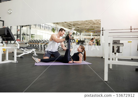Woman practicing with fitness instructor. 53672912