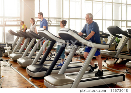 Group of people running on treadmills. Group of people running on treadmills. 53673048