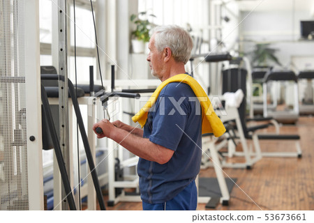 Elderly man exercising at gym. Elderly man exercising at gym. 53673661