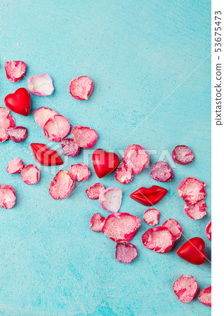 Chocolate heart and lips shaped candies with rose candied sugared petals. Blue background. Top view. 53675473