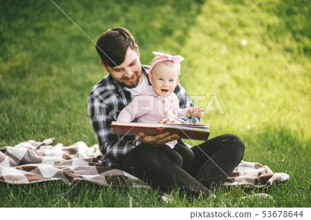 Father and his baby daugter playing in a park Father and his baby daugter playing in a park 53678644