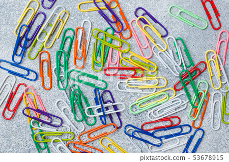 Bright colored paper clips on a gray Desk. concept 53678915