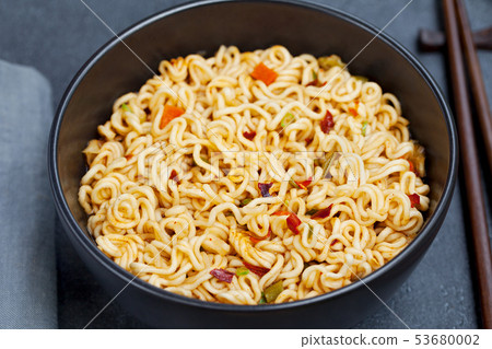 Noodles with vegetables in a bowl on grey stone background. Close up. 53680002