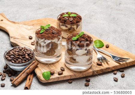 Classic tiramisu dessert in a glass on dark concrete background 53680003