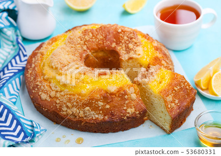 Lemon bundt cake with cup of tea. Blue background. Close up. Lemon bundt cake with cup of tea. Blue background. Close up. 53680331