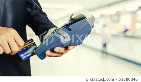hand using credit card swiping machine to pay and 53680840