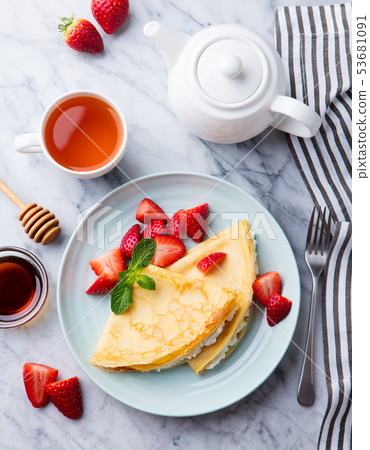 Crepes, thin pancakes with fresh strawberry and ricotta, cream cheese. Marble background. Top view. Crepes, thin pancakes with fresh strawberry and ricotta, cream cheese. Marble background. Top view. 53681091