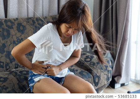 woman suffering from abdominal pain while sitting 53685133