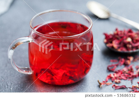 Hibiscus tea in glass cup. Grey background. Close up. Hibiscus tea in glass cup. Grey background. Close up. 53686332