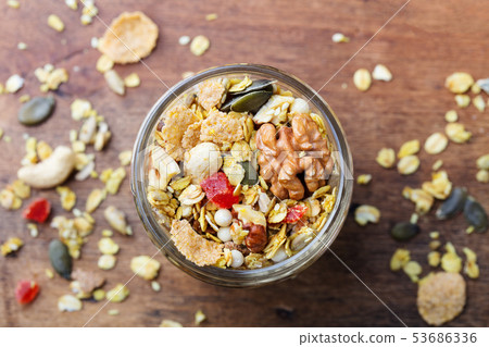 Granola, muesli in glass jar. Organic oats with turmeric, nuts, fruits and berries. Top view. 53686336