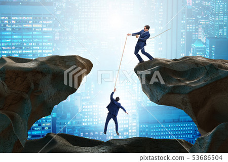 Businessman helping colleague with rope 53686504