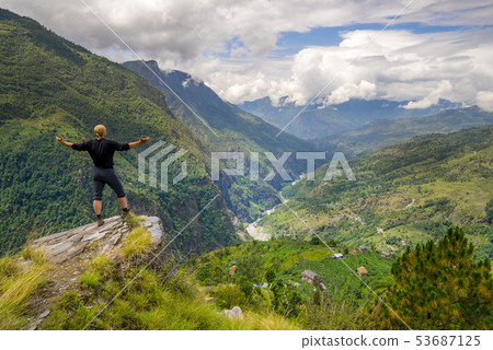 Man standing on hill top in Himalayas Man standing on hill top in Himalayas 53687125