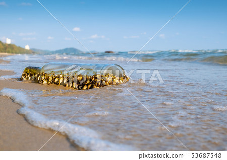 Old glass bottle with sea shell on the beach. Old glass bottle with sea shell on the beach. 53687548