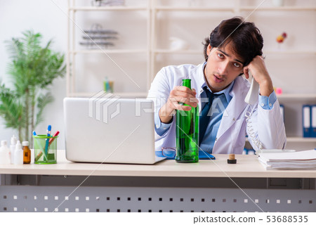 Young male doctor drinking in the office Young male doctor drinking in the office 53688535