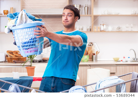 Young man husband doing clothing ironing at home  53689344