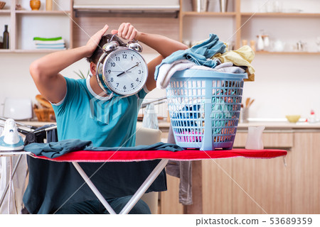 Young man husband doing clothing ironing at home  53689359