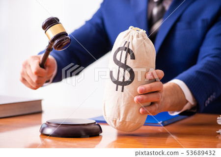 Young male judge sitting in courtroom Young male judge sitting in courtroom 53689432