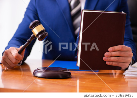 Young male judge sitting in courtroom  53689453