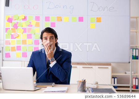 Young handsome employee in front of whiteboard with to-do list   53689644