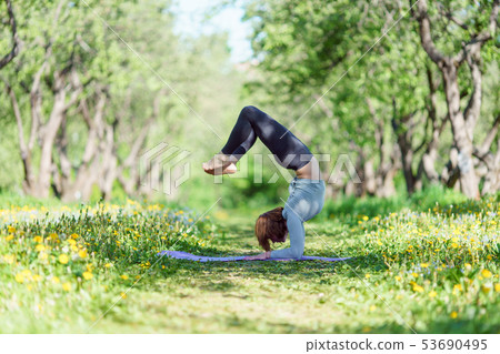 Image of girl standing on hands doing yoga in forest 53690495