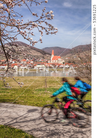 Cyclists against Weissenkirchen village in Wachau 53691225
