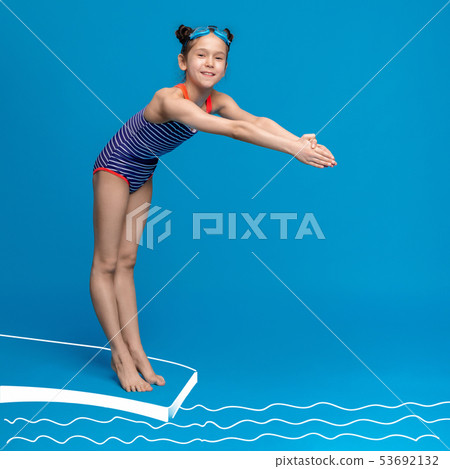 Cute girl about to dive off diving board into swimming pool 53692132