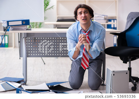 Young male employee unhappy with excessive work Young male employee unhappy with excessive work 53693336