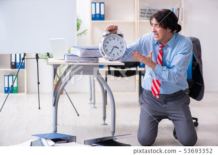 Young male employee unhappy with excessive work  53693352