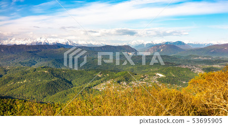 View at sunset on a green hilly valley with houses 53695905