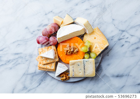 Assortment of cheese, grapes and crackers. Marble background. Top view. Copy space. Assortment of cheese, grapes and crackers. Marble background. Top view. Copy space. 53696273
