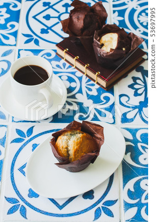 Cup of coffee and muffins on kitchen table. 53697995