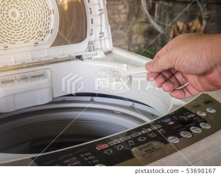 A man pouring laundry detergent or washing powder A man pouring laundry detergent or washing powder 53698167