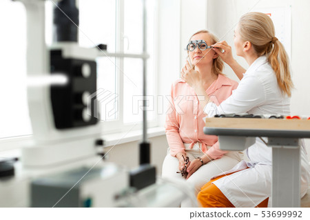 Gentle long-haired doctor correcting placement of glass device Gentle long-haired doctor correcting placement of glass device 53699992