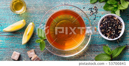 Tea cup with mint leaf and lemon. Wooden background. Copy space. Top view. 53700841