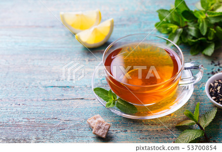 Tea cup with mint leaf and lemon. Wooden background. Copy space. Tea cup with mint leaf and lemon. Wooden background. Copy space. 53700854