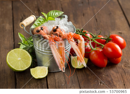 Raw langoustine in a bucket with vegetables and Raw langoustine in a bucket with vegetables and 53700965