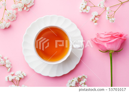 Cup of tea with fresh flowers on pink background. Copy space. Top view. 53701017