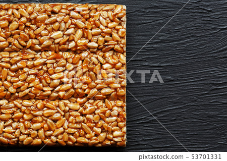 Tile kozinaki from sunflower seeds on a black 53701331