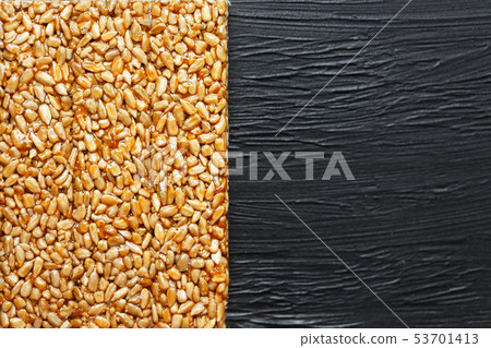 Tile kozinaki from sunflower seeds on a black Tile kozinaki from sunflower seeds on a black 53701413