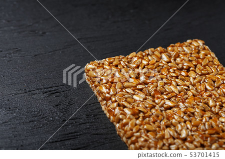 Tile kozinaki from sunflower seeds on a black Tile kozinaki from sunflower seeds on a black 53701415