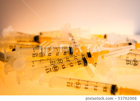 Syringes on orange background 53702008